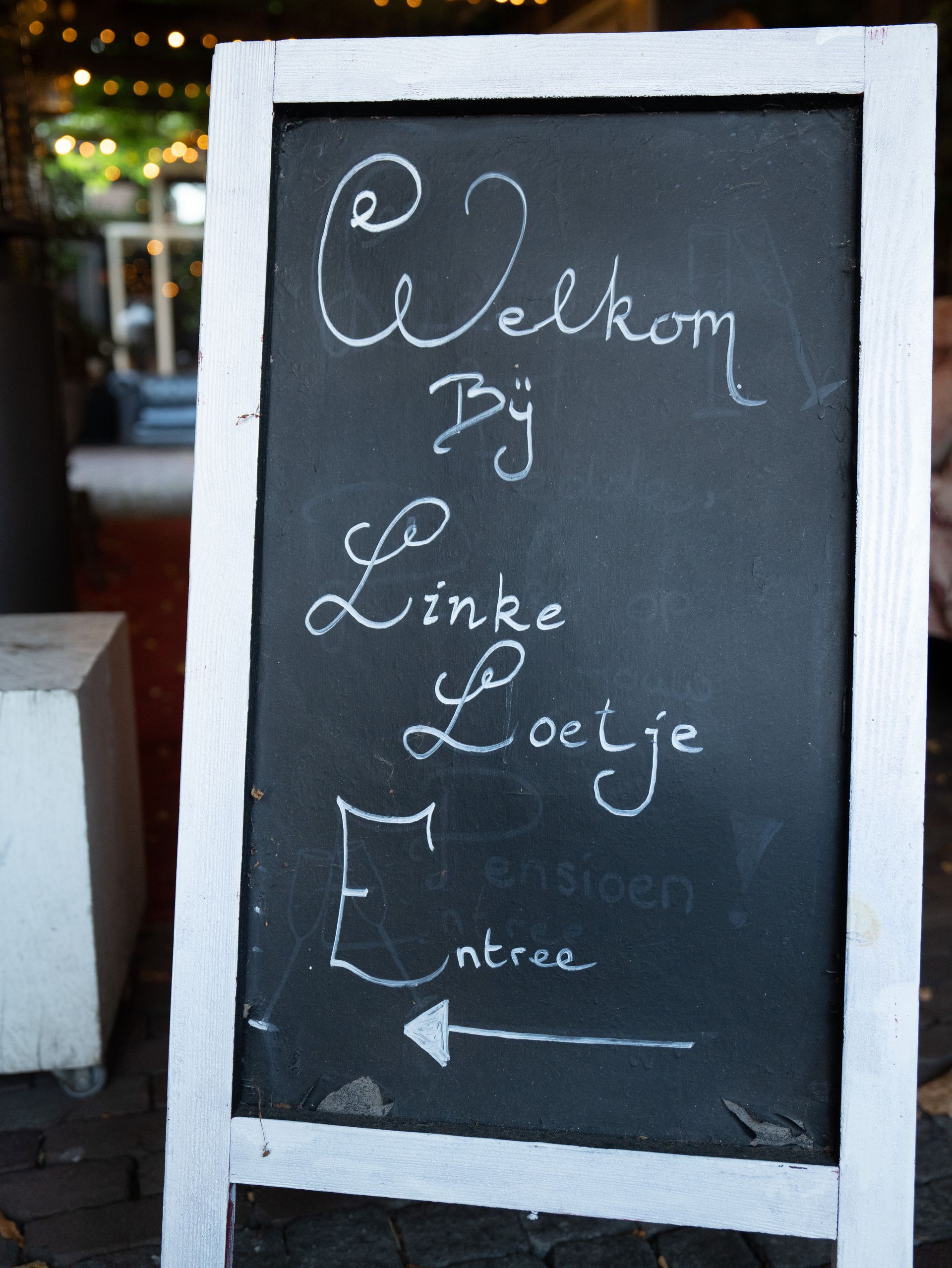 Een bord met de woorden welkom van linke loetje erop geschreven. Bij Linke Loetje