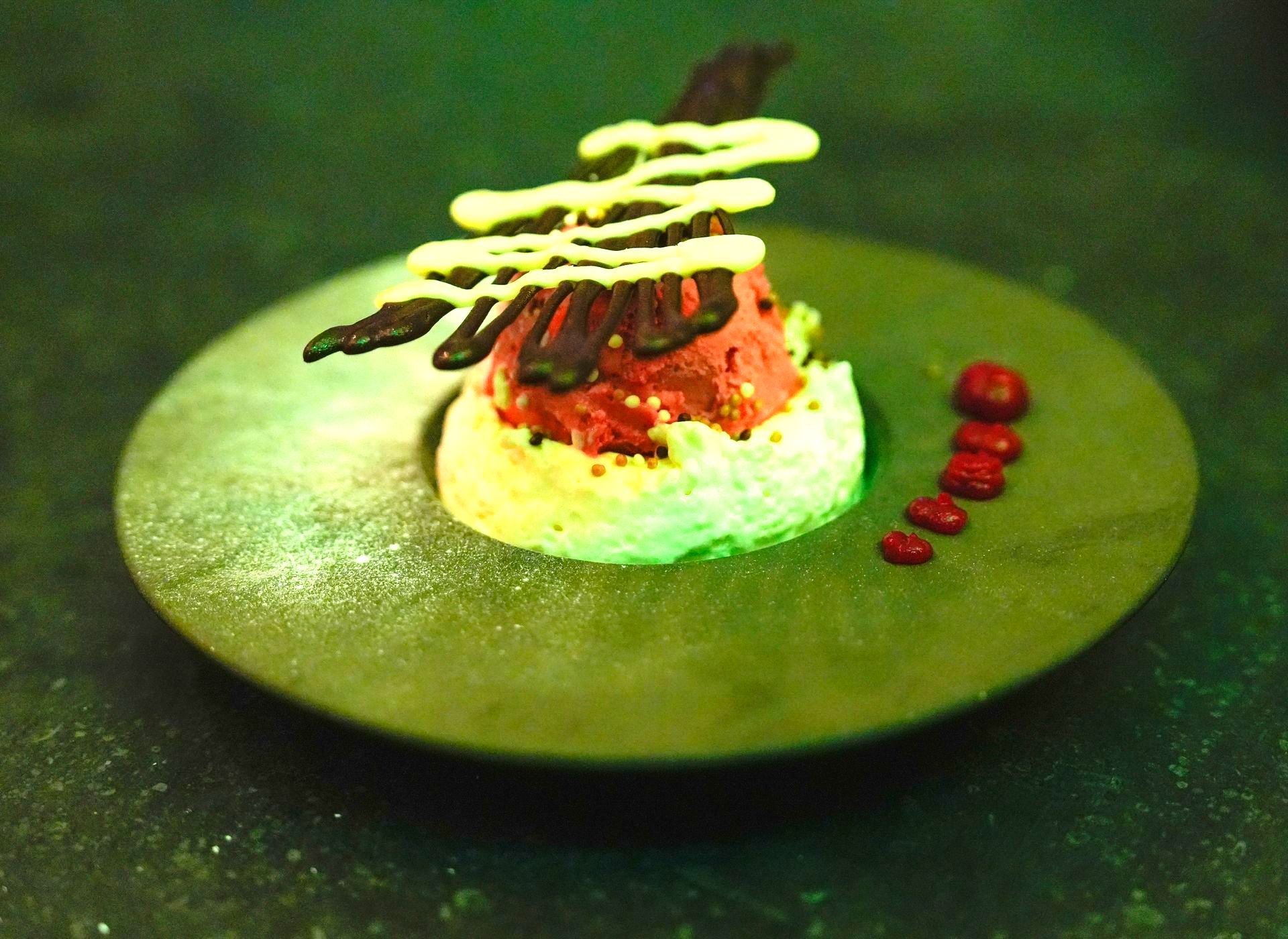 Een groen bord met een dessert erop bij Linke Loetje