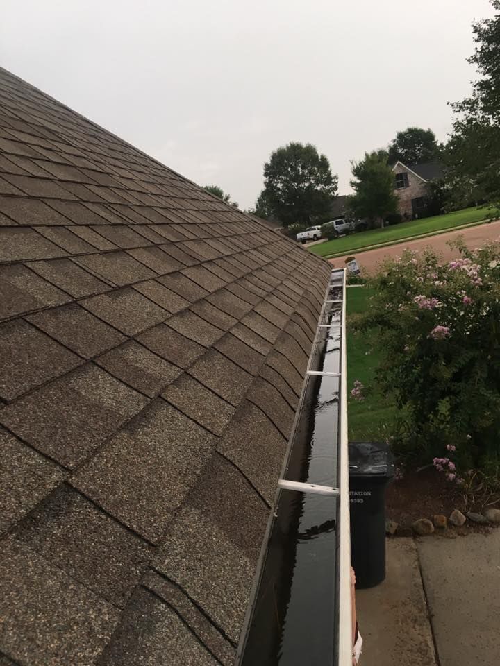 There is a gutter on the roof of a house.