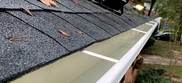 A close up of a gutter on the roof of a house.
