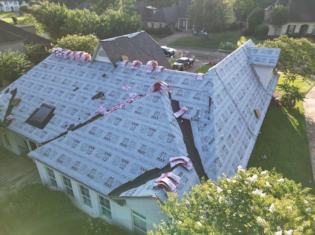 House roof partially covered with roofing material, in progress.
