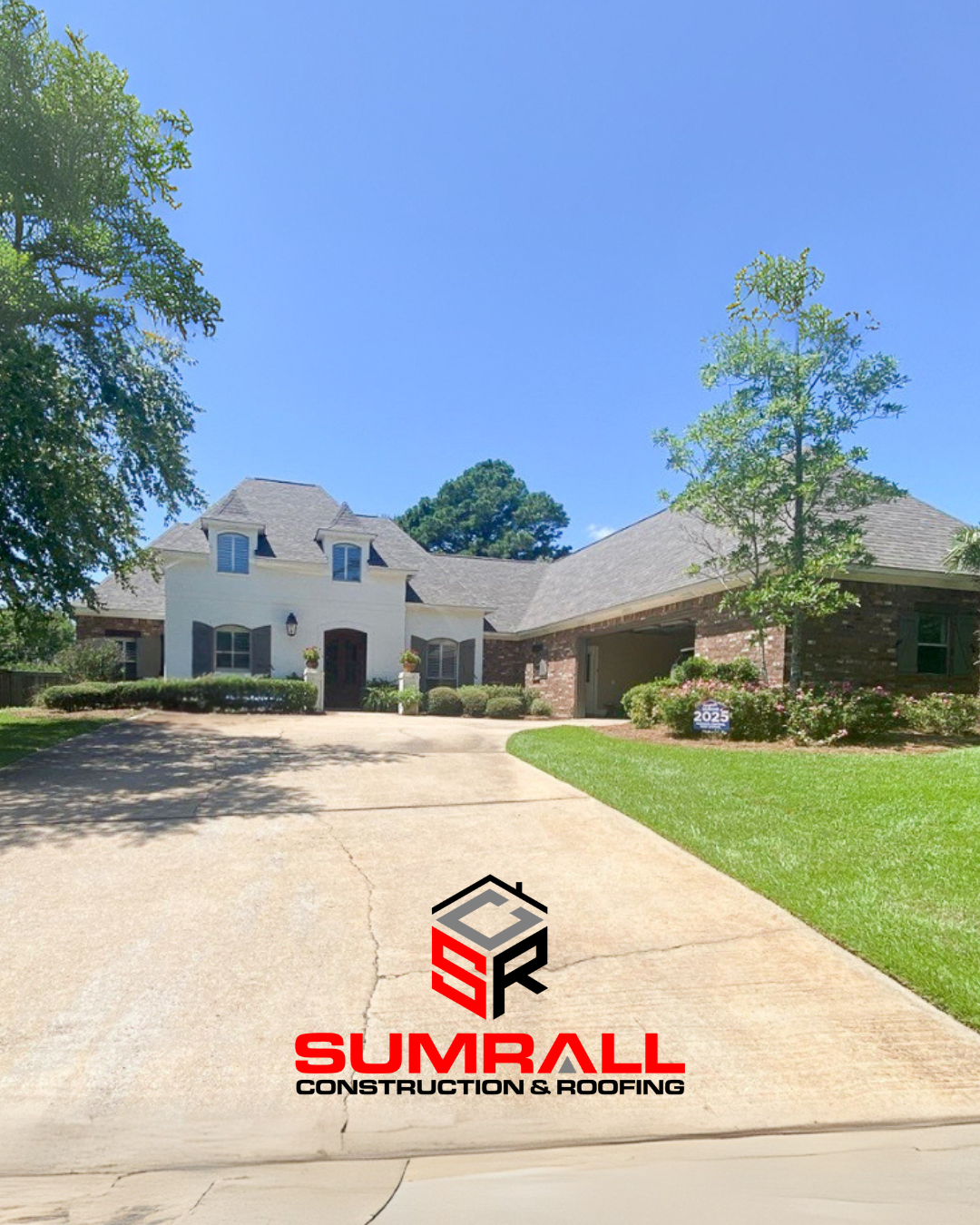 House with long driveway, green lawn, and blue sky. Sumrall Construction & Roofing logo is visible.