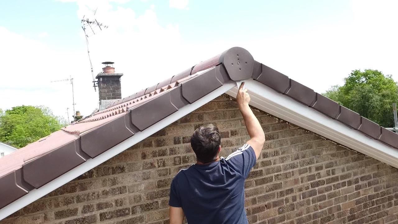 A man is working on the roof of a house.