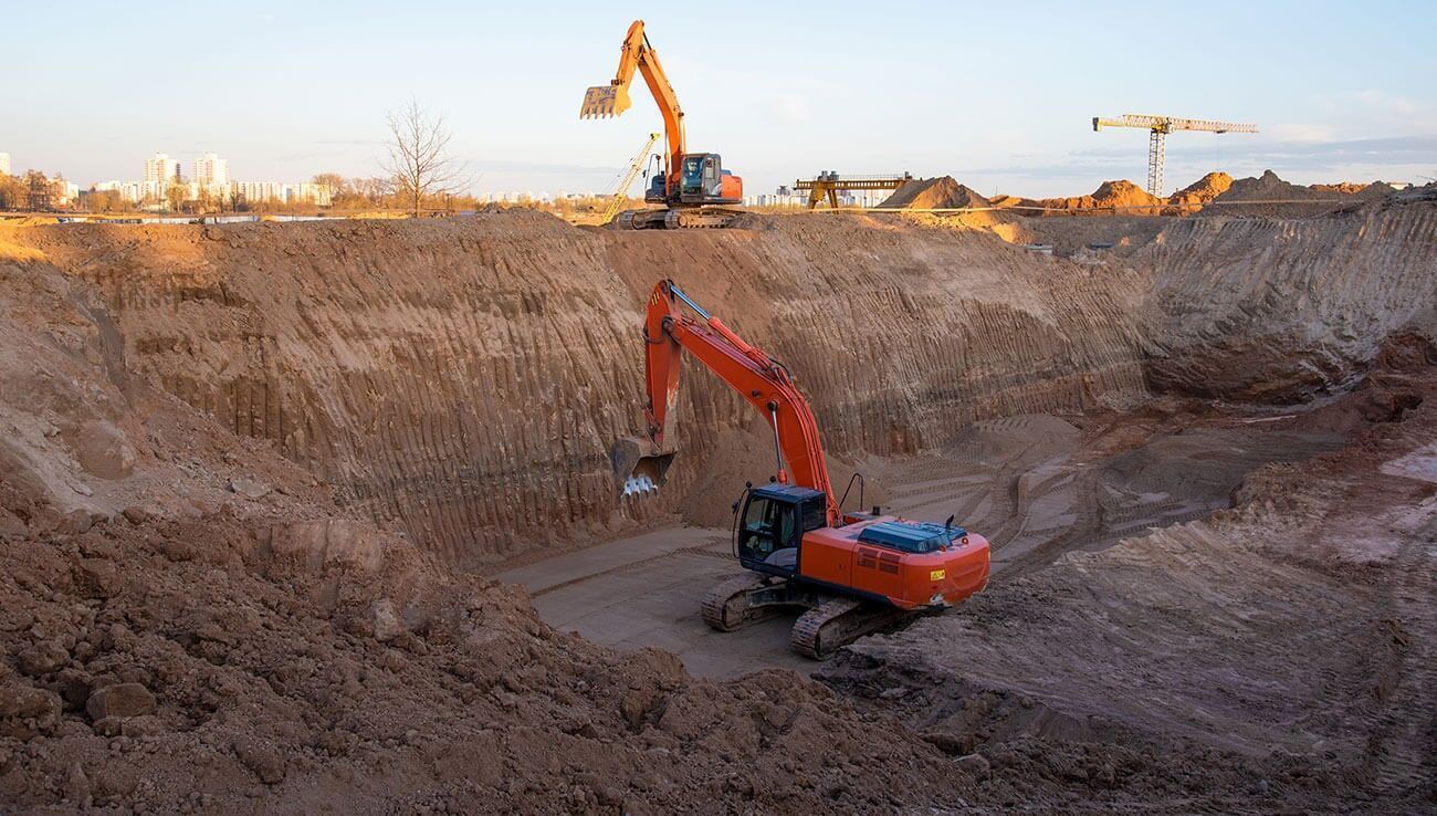 Una gran excavadora está cavando un gran agujero en el suelo.