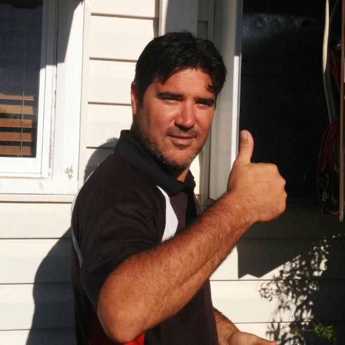 Man with dark hair and a beard gives a thumbs-up outside a building  — Robert Coony Electrician in Nambucca Heads, NSW