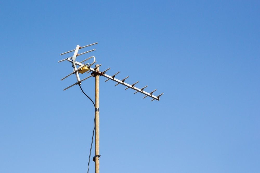TV Antenna Mounted on a Pole Against a Clear Blue Sky — Robert Coony Electrician in Nambucca Heads, NSW