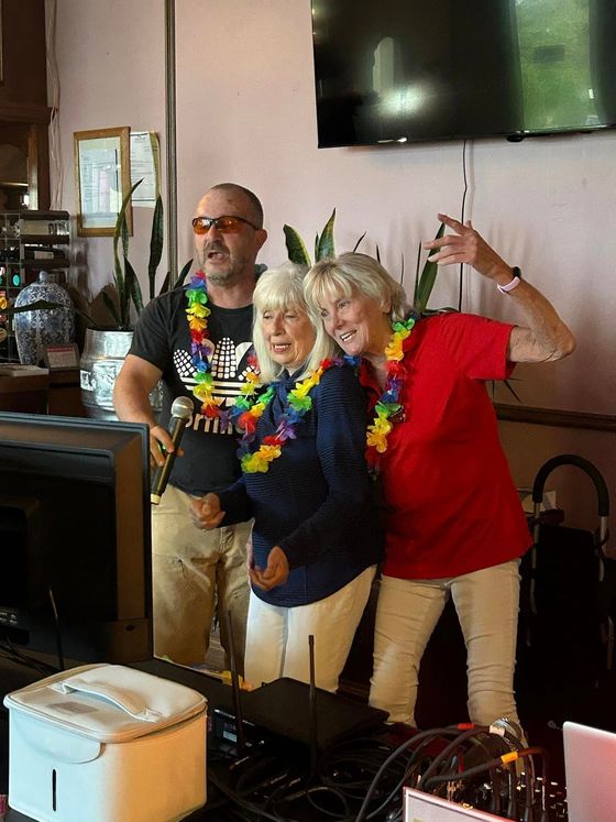 A man and two women are standing next to each other in a room.