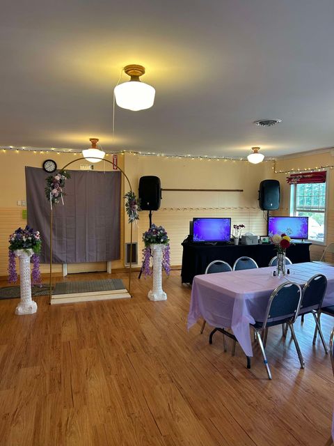 A large room with wooden floors and tables and chairs.