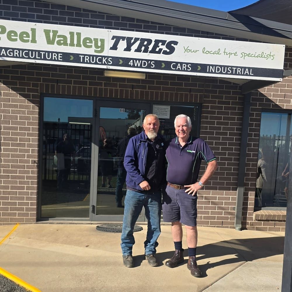 Two Men Are Standing in Front of a Peel Valley Tyres Store — Peel Valley Tyres in Taminda, NSW