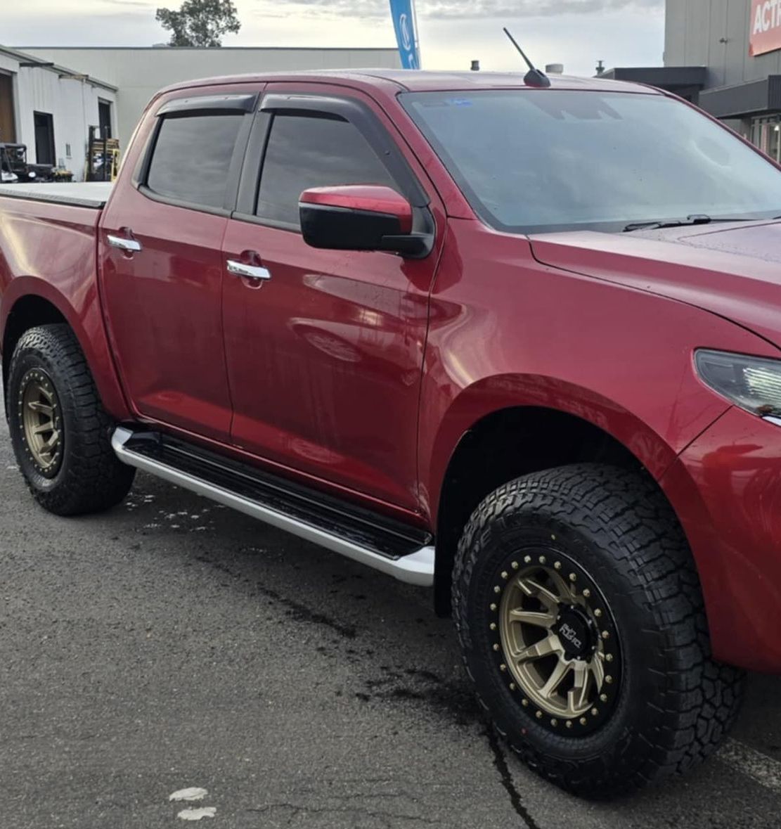 A Red Ute Is Parked In Front Of A Black Building — Peel Valley Tyres in Taminda, NSW