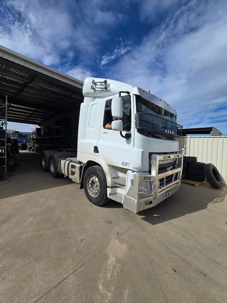 A White Semi Truck is Parked in Front of a Warehouse — Peel Valley Tyres in Taminda, NSW