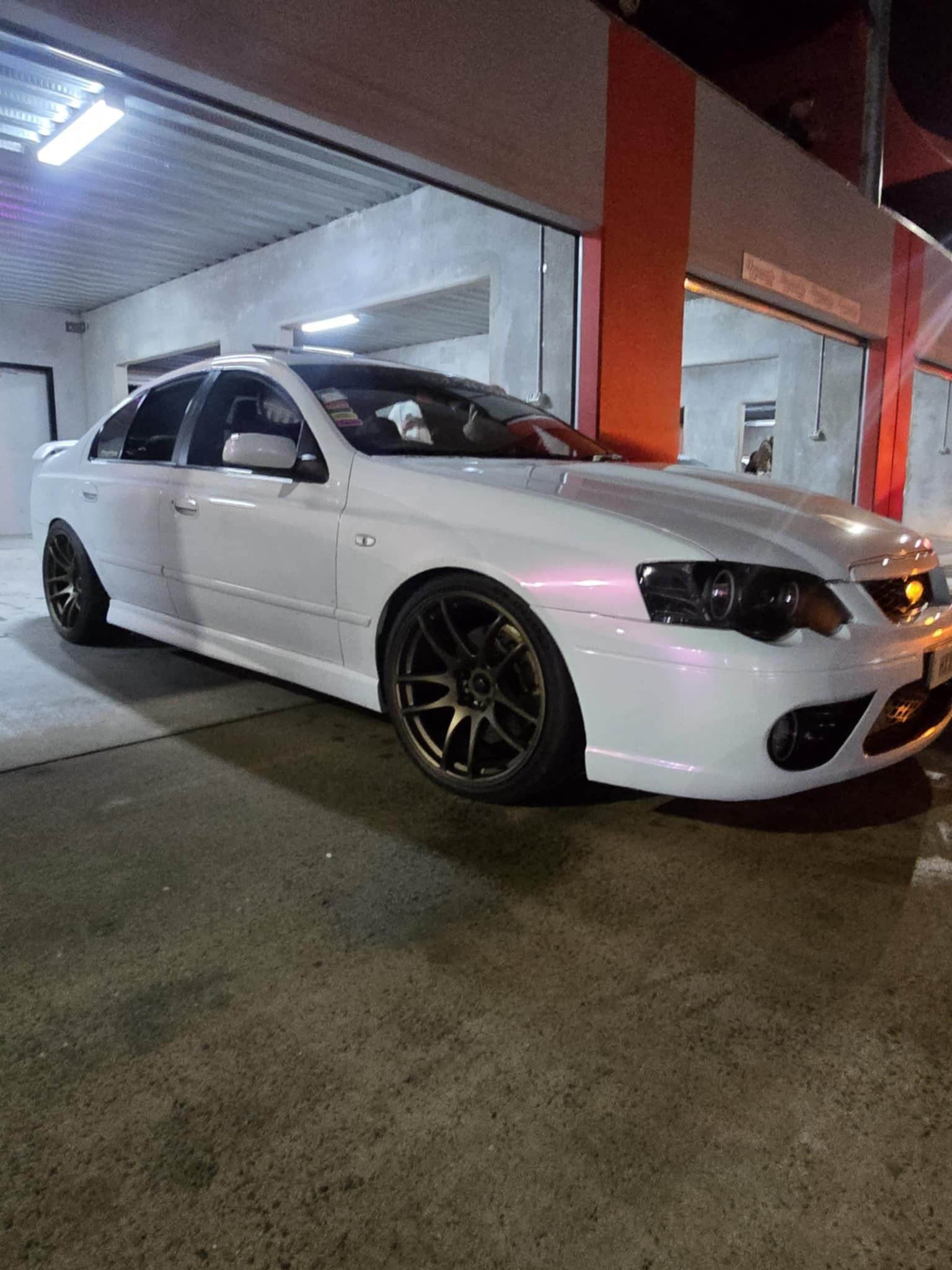 A White Sedan s Parked in a Parking Lot Next to a Fence — Peel Valley Tyres in Taminda, NSW
