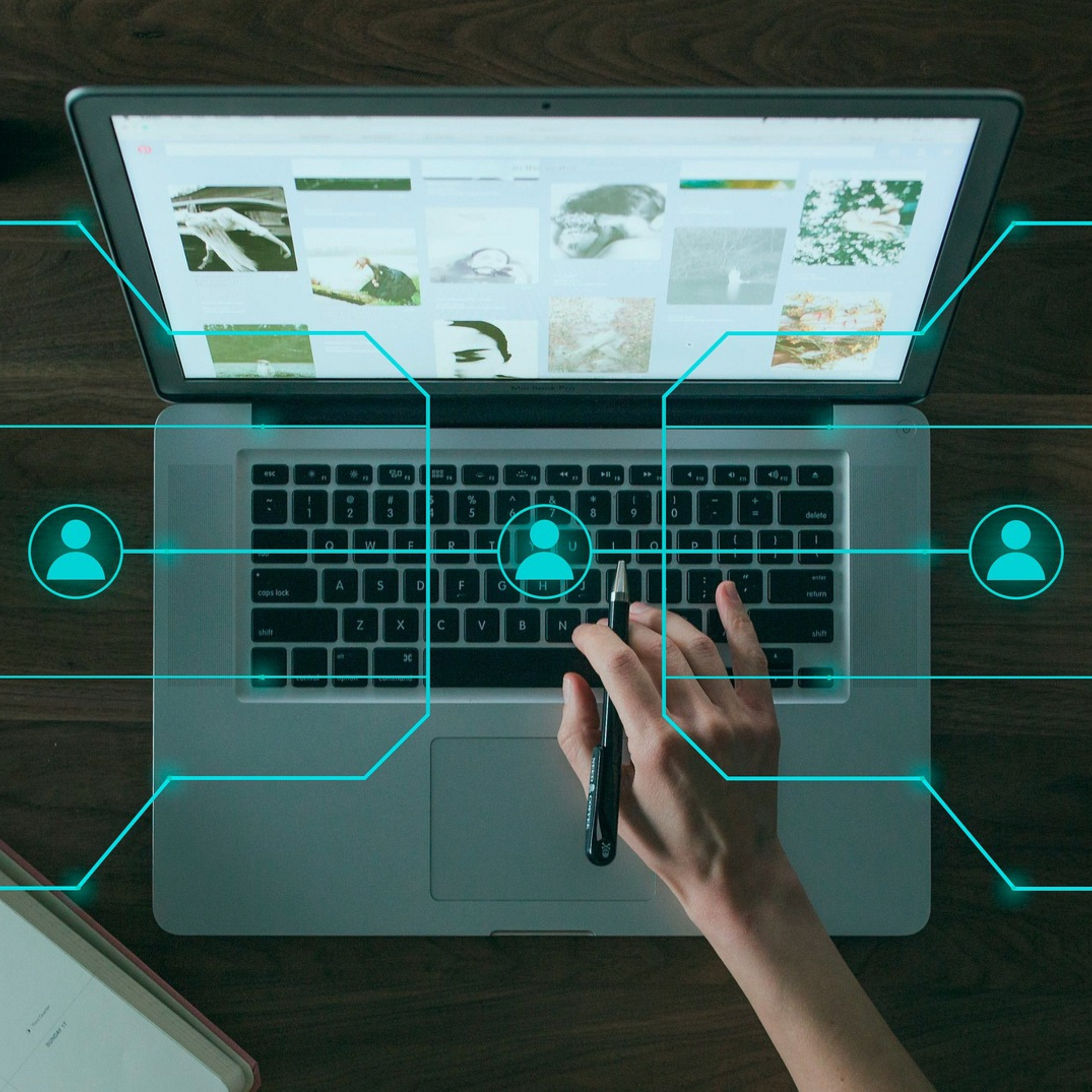 Uma pessoa está digitando em um laptop com uma caneta na mão