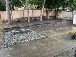 A backyard with a fire pit and a wooden fence