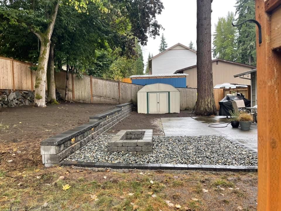 A backyard with a fire pit and a shed.