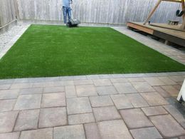 A man is cutting a lawn with a lawn mower in a backyard.