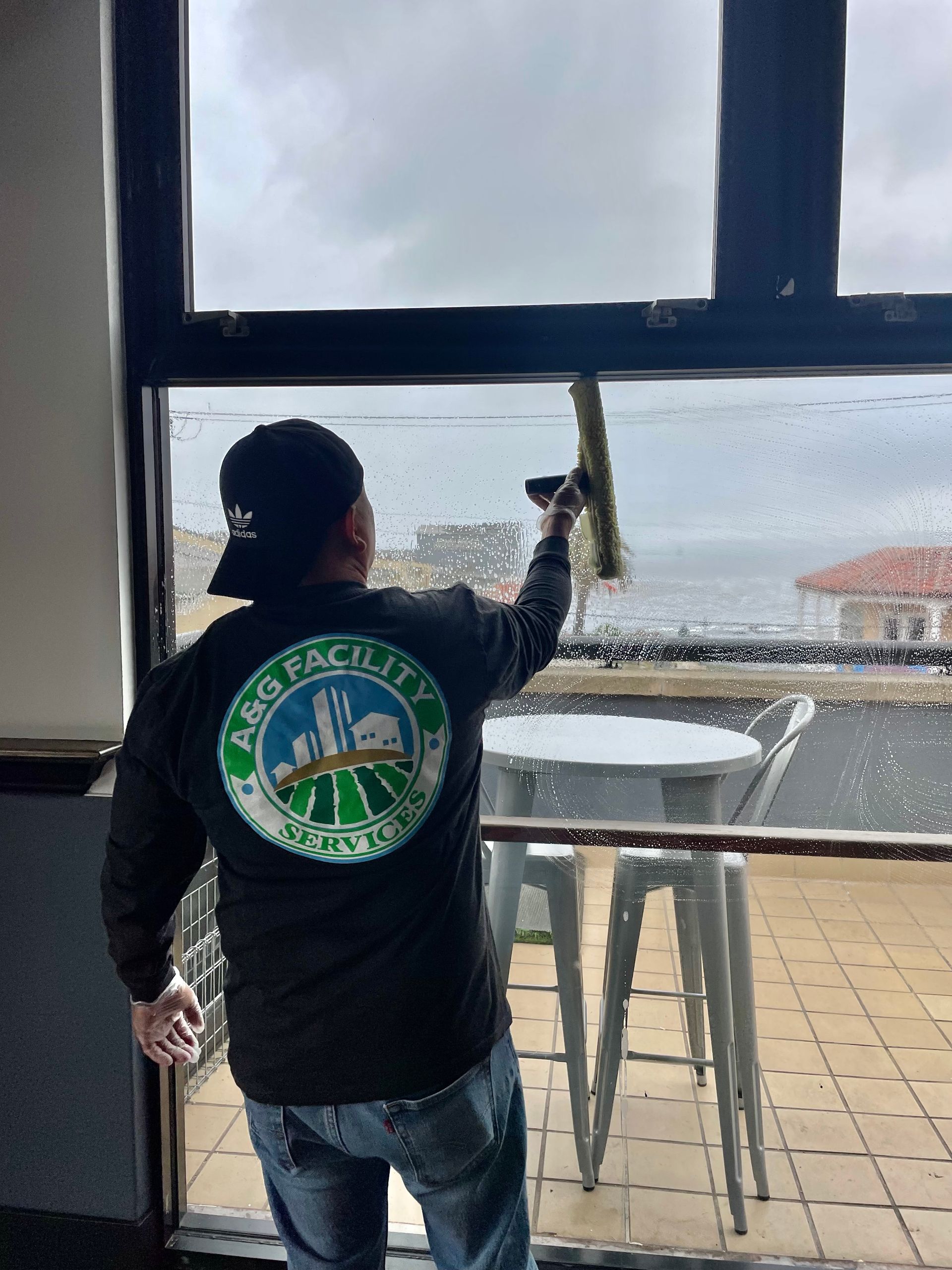 A man is cleaning a window with a squeegee.