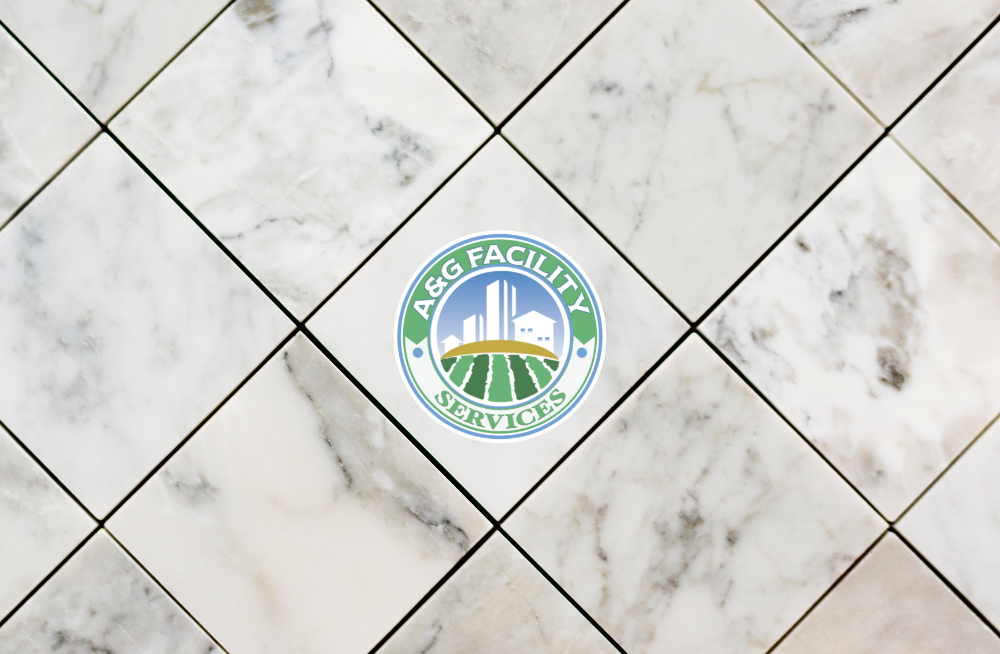 A logo for a & g facility is on a tile floor