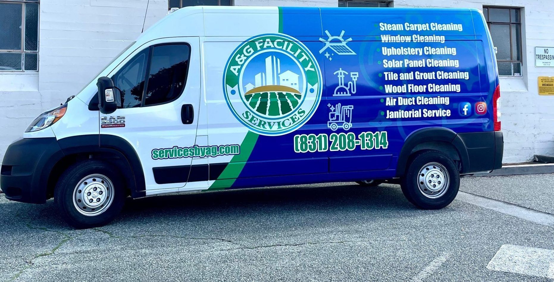 A blue and white van is parked in front of a building.