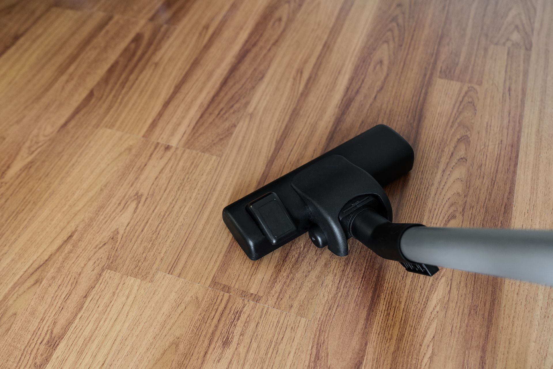 A vacuum cleaner is sitting on a wooden floor.