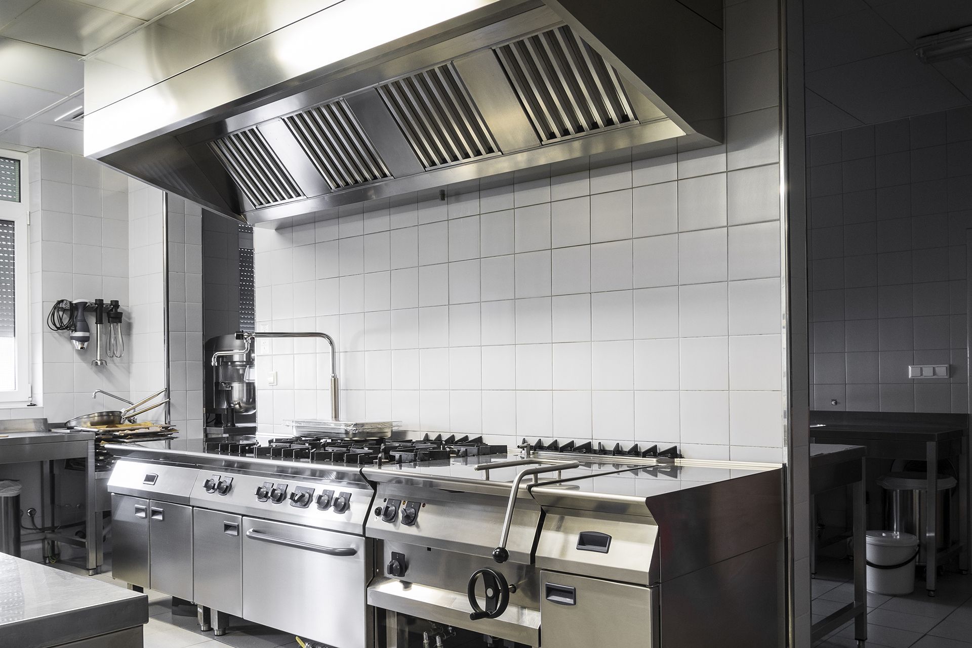 A kitchen with stainless steel appliances and white tiles