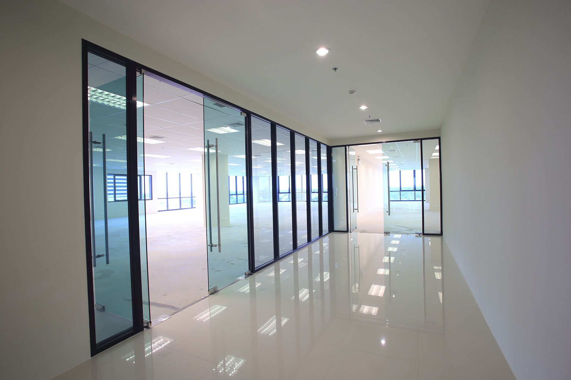 An empty hallway with a lot of glass doors