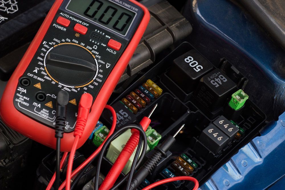Auto Electrician In Wollongong Using A Multimeter To Check On A Vehicle's Fuse