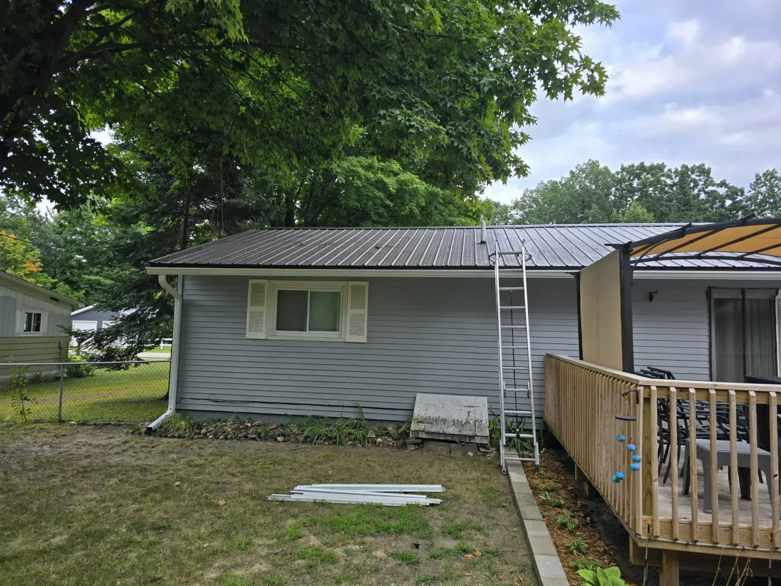 A small house with a metal roof and a wooden deck.