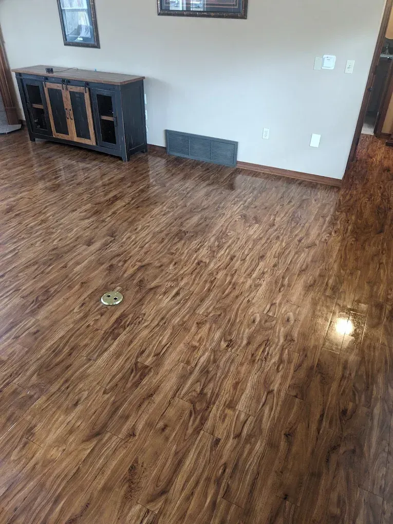 Wooden floor with a reflective glossy finish; a black entertainment cabinet.