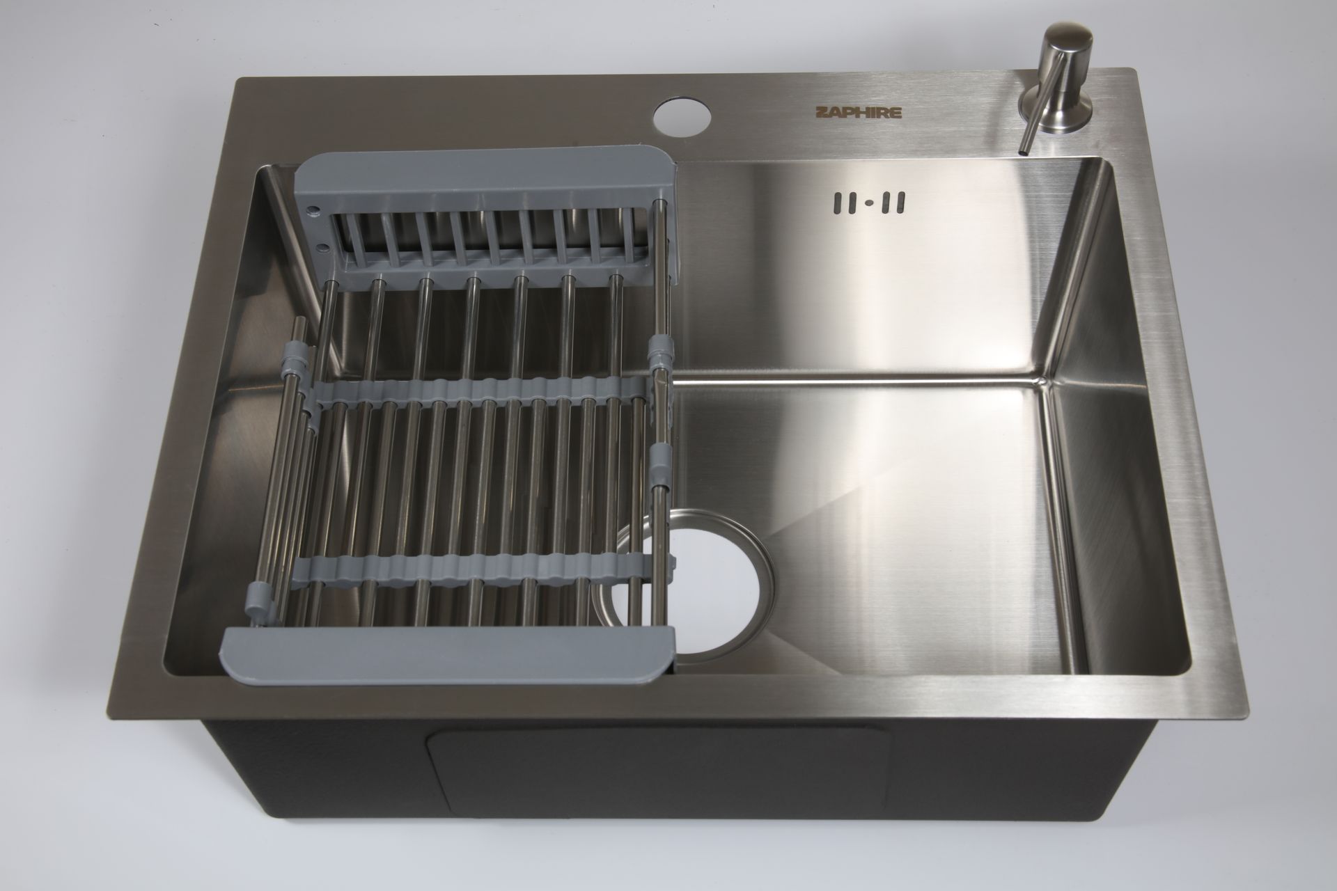 Fregadero de cocina de acero inoxidable con grifo, tabla de cortar y accesorios sobre encimera.