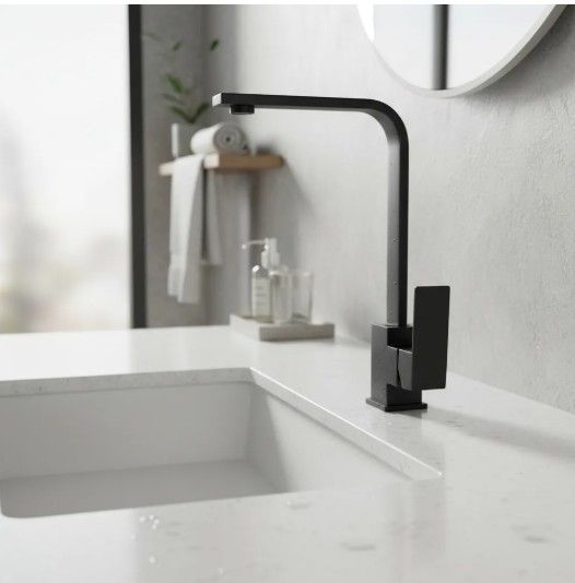 Grifo negro sobre un lavabo blanco en un baño moderno.