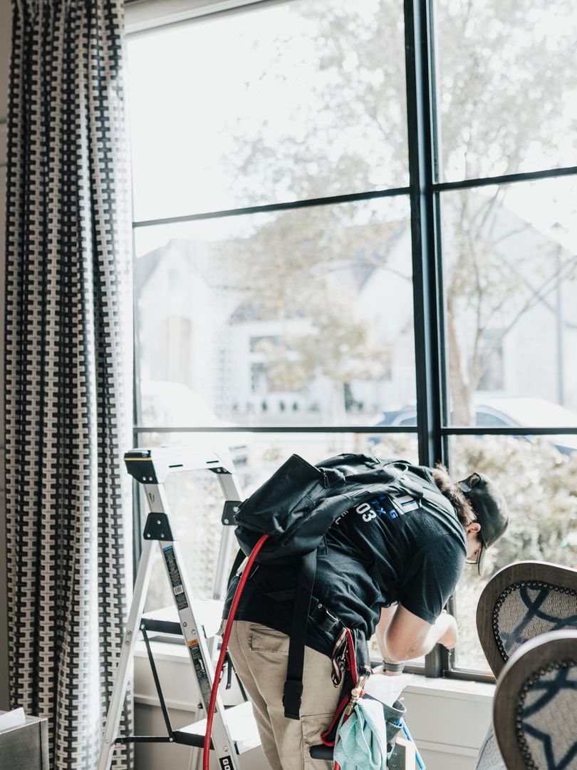 Two men are installing a window in a room.