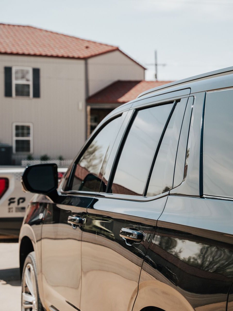 A black suv is parked in front of a house