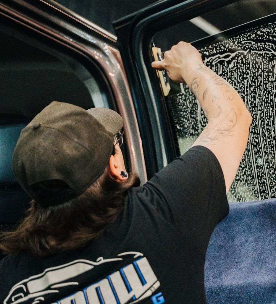 A man wearing a black shirt with the word g on it