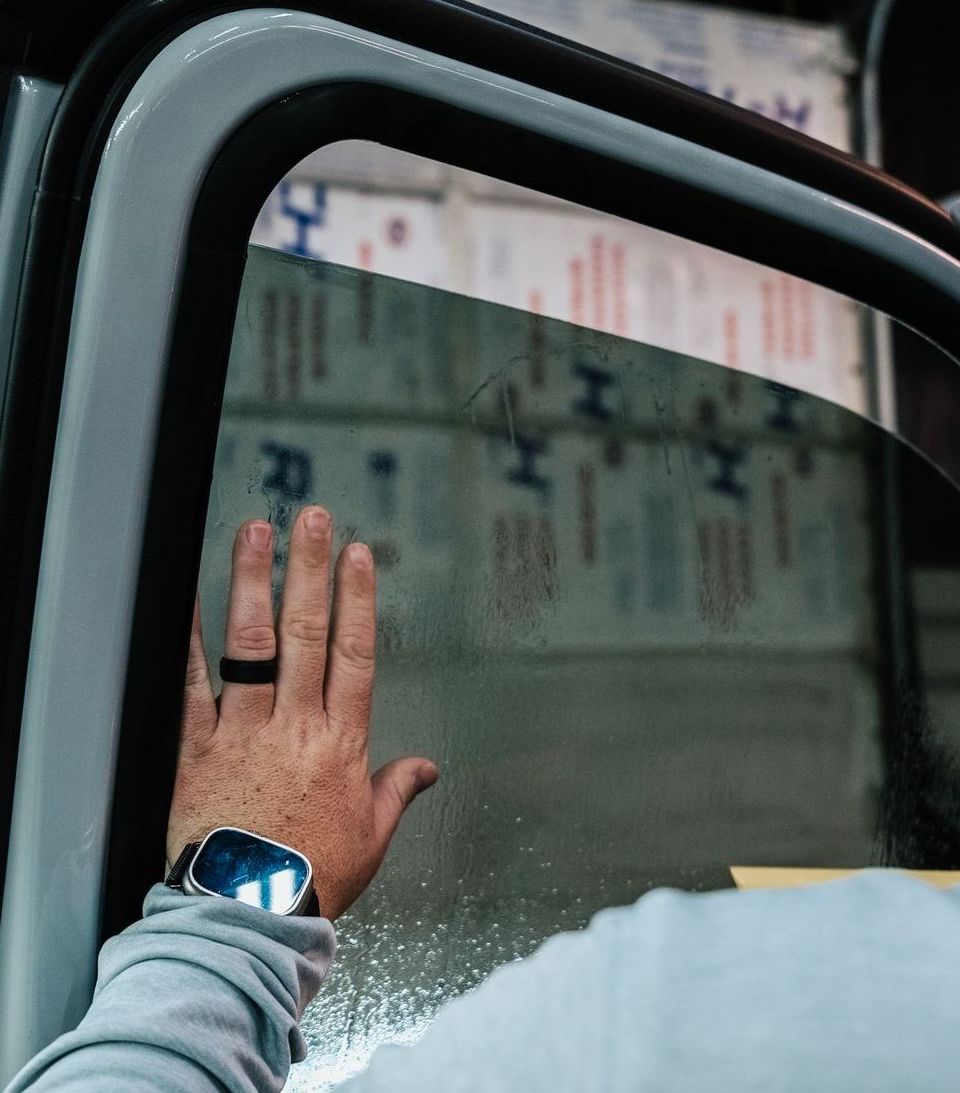 A person 's hand is reaching out of a car window