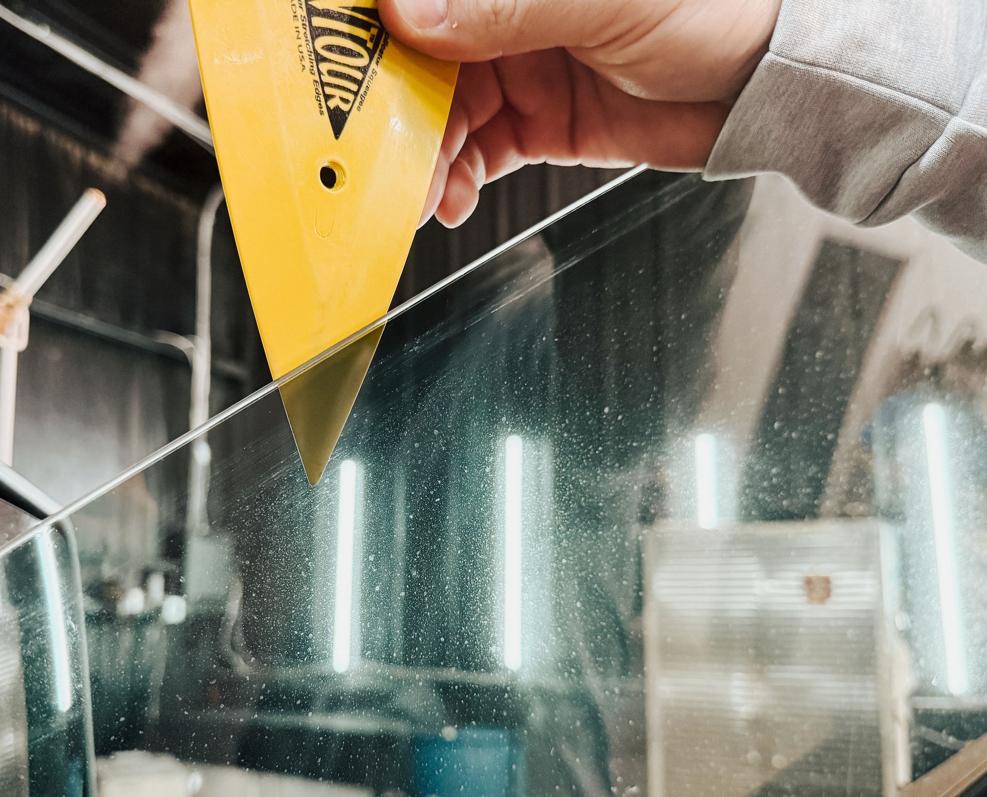 A person is holding a yellow tool that says ' folia ' on it