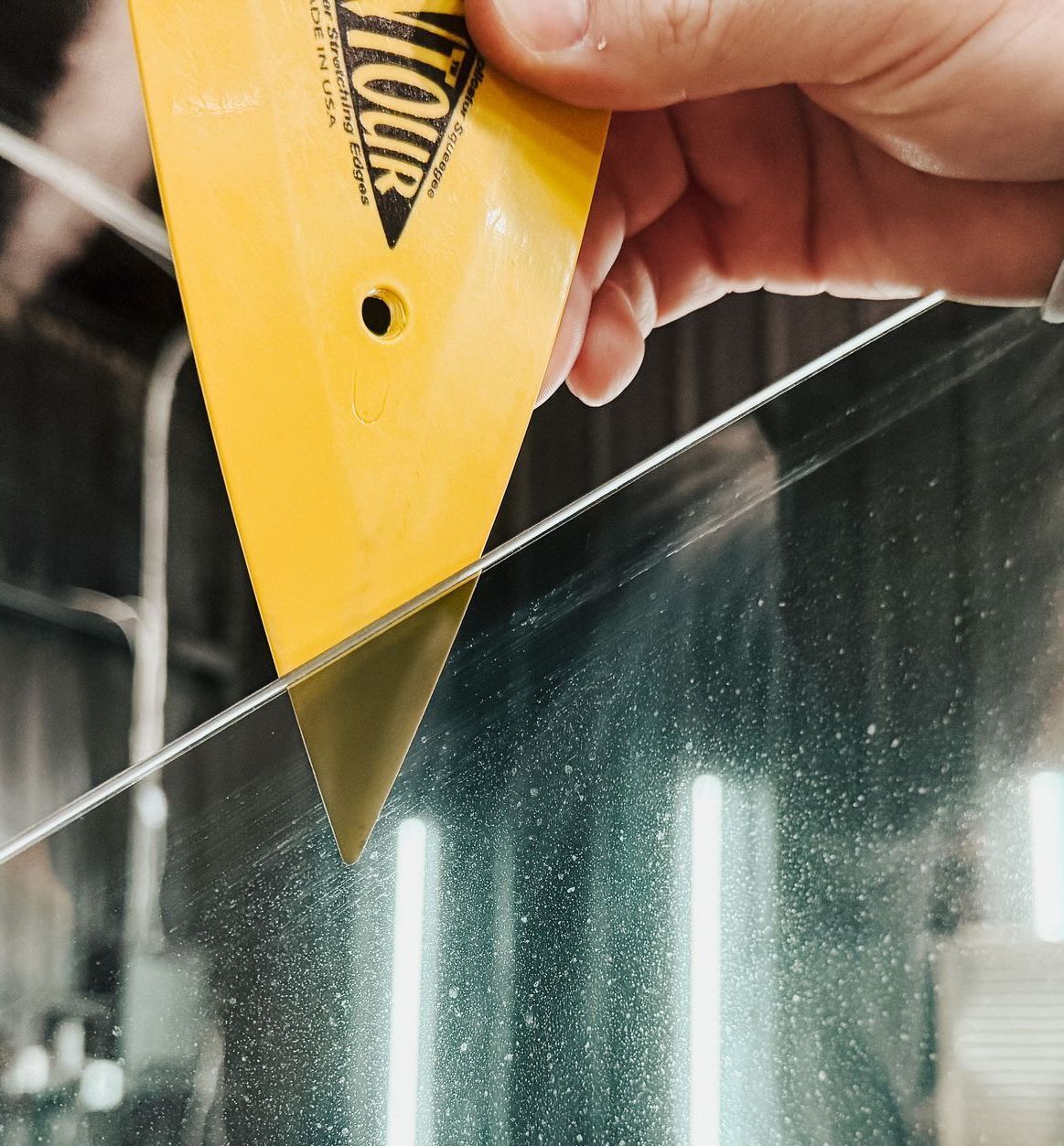 A person is holding a yellow tool that says contour on it