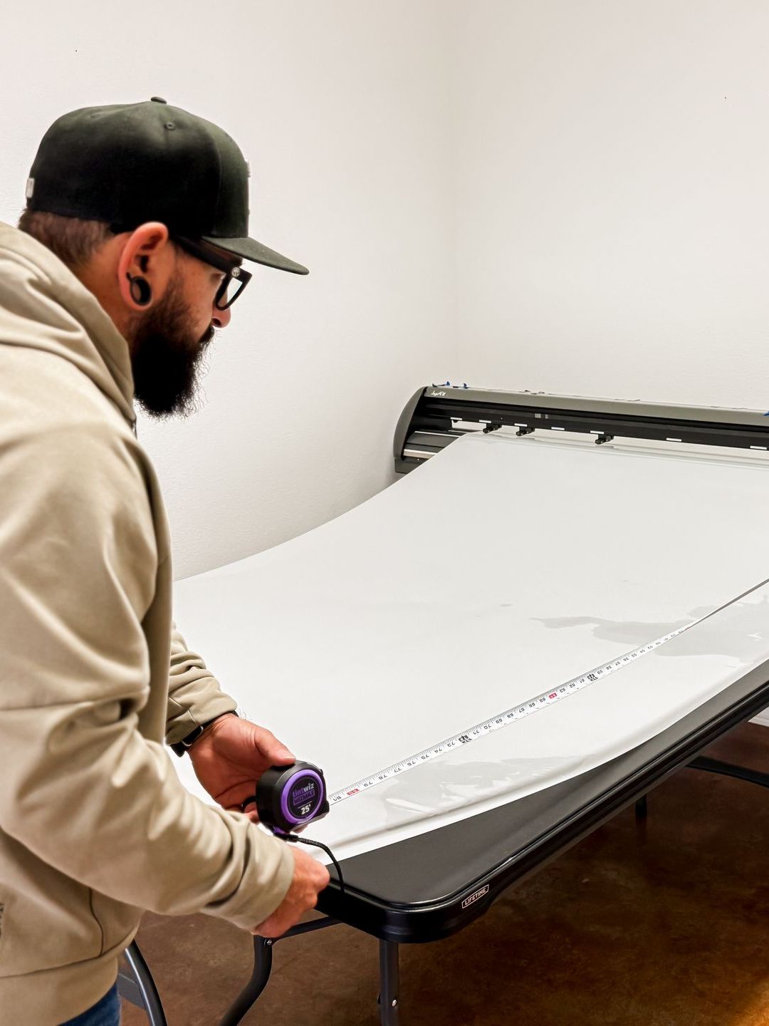 A man is measuring a table with a tape measure