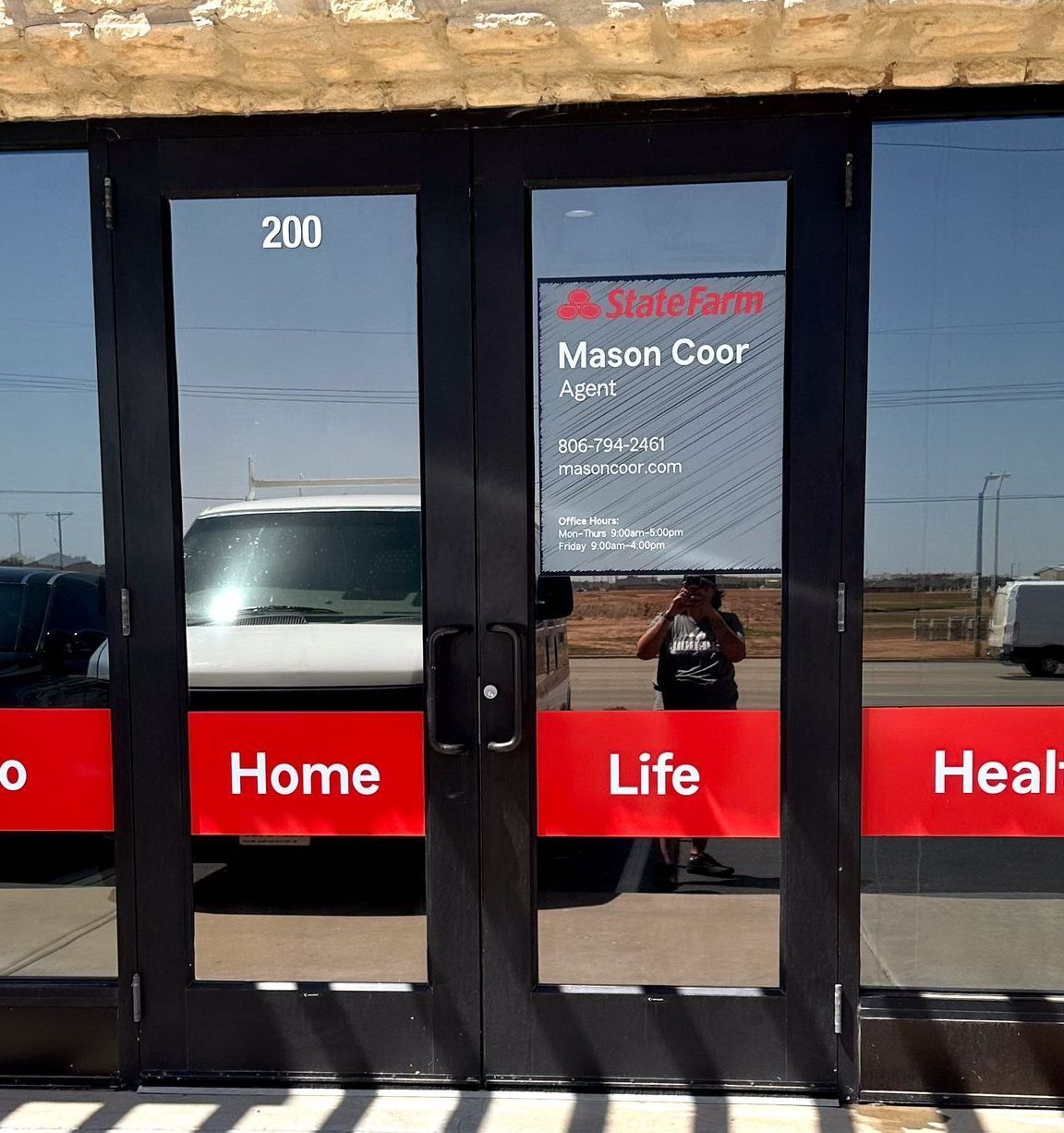 A white van is parked in front of a door that says home life and heal