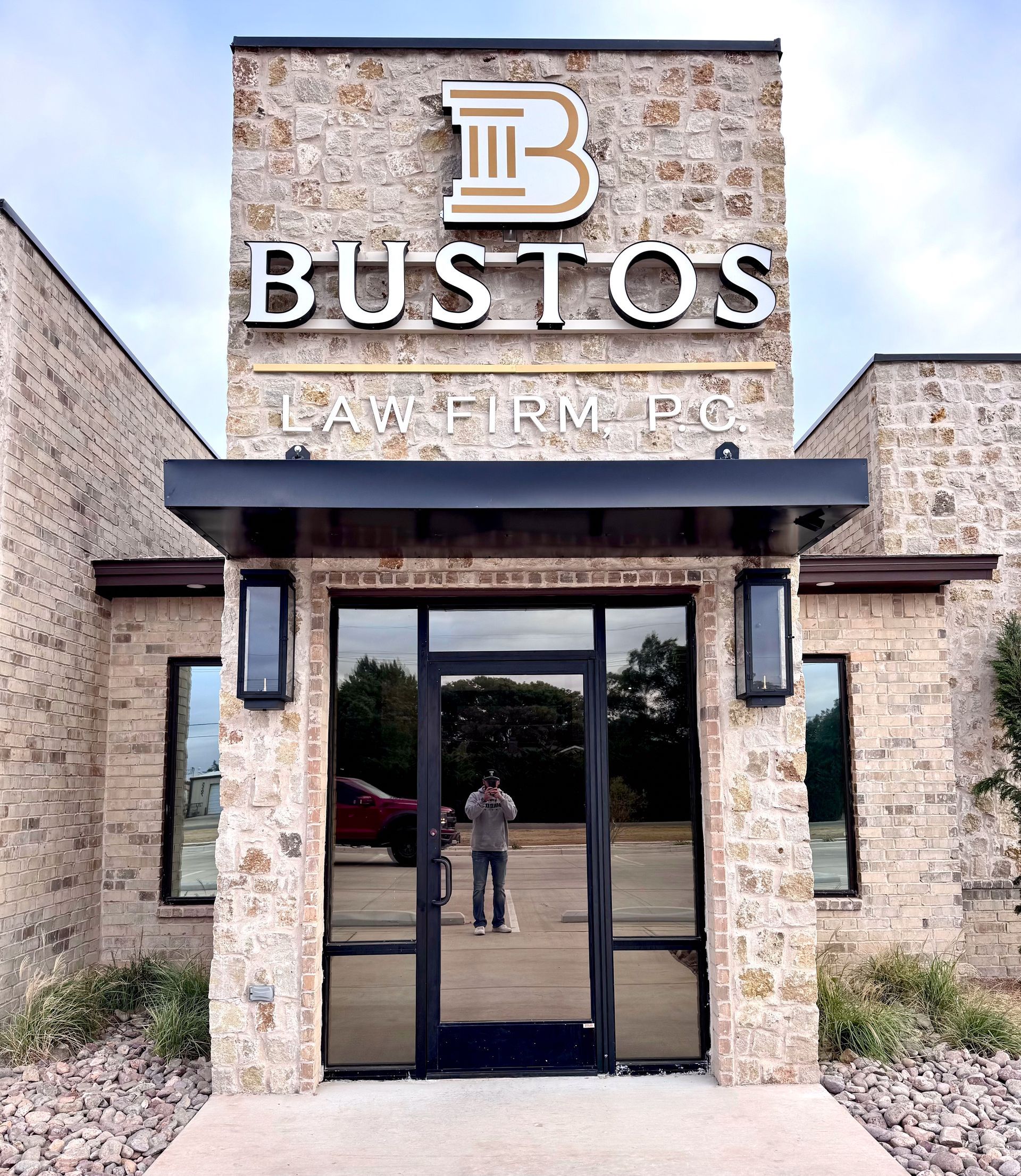 A man is standing in front of a bustos law firm
