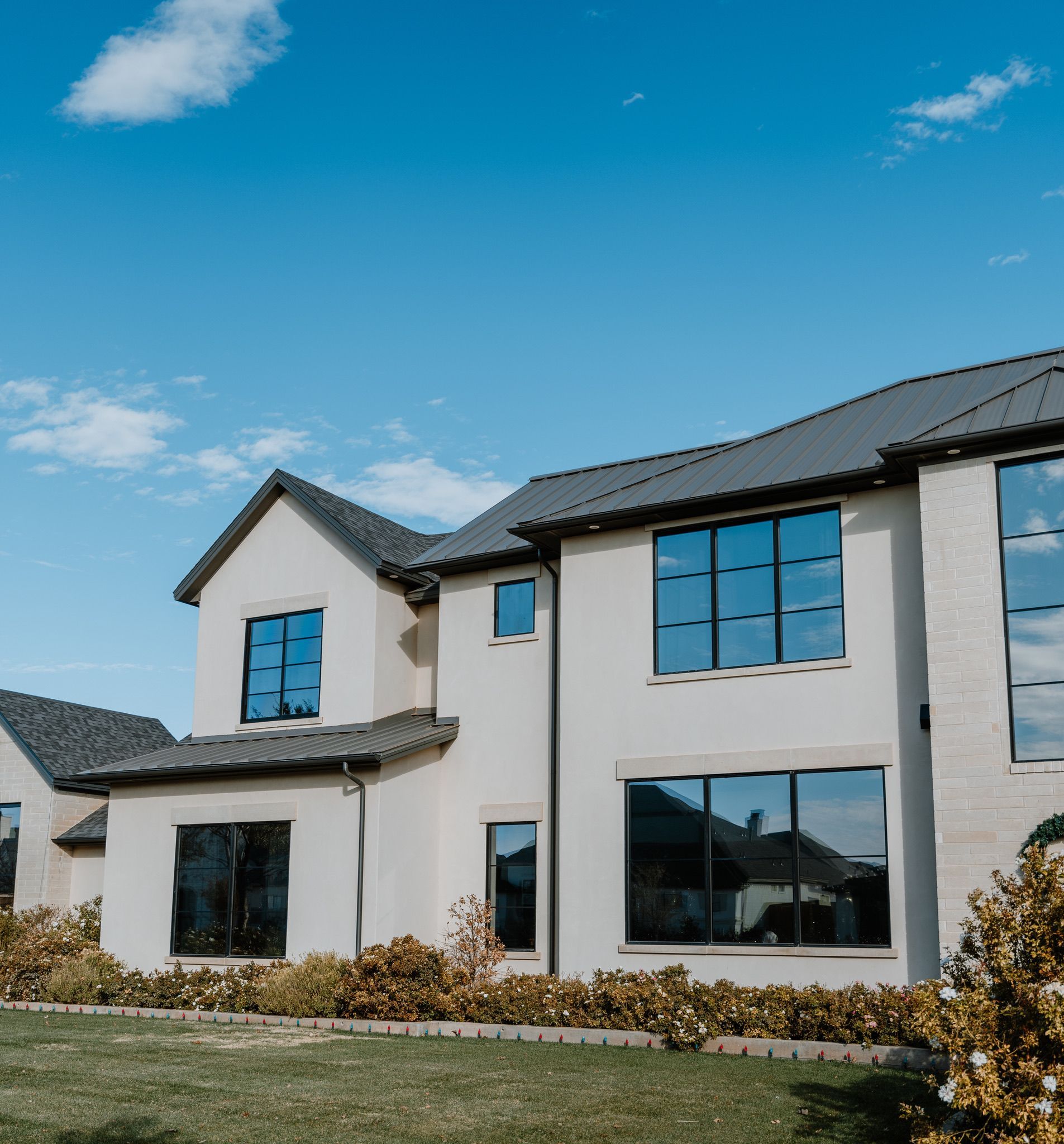 A large white house with a gray roof and lots of windows