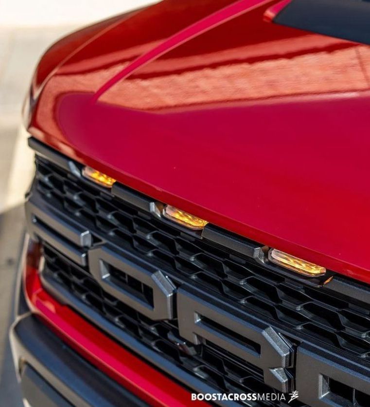 A close up of the front of a red ford truck