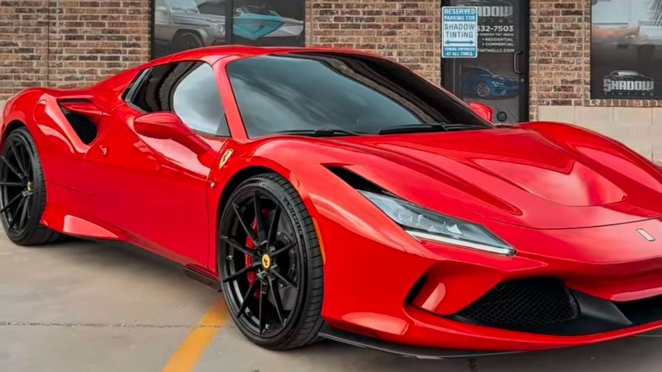 A red sports car is parked in a parking lot.