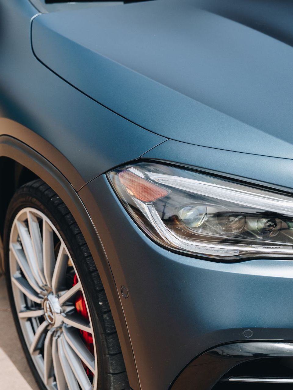A close up of the headlight of a blue car