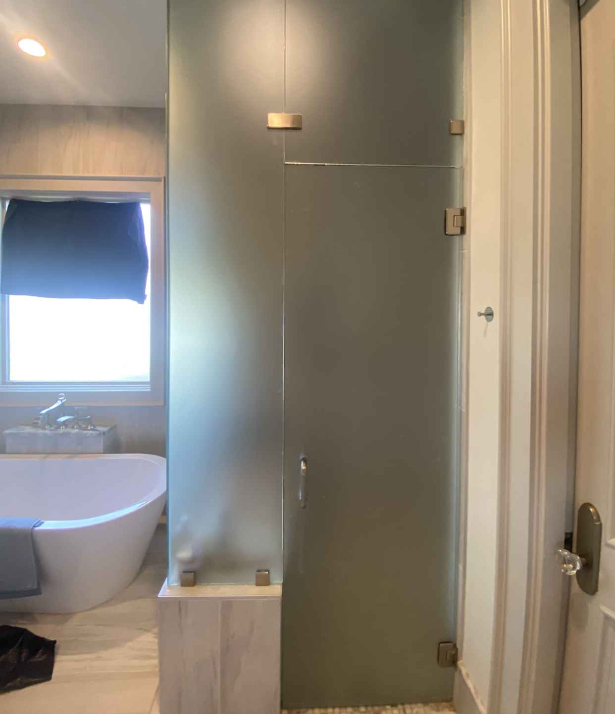 A bathroom with a bathtub and a glass shower door