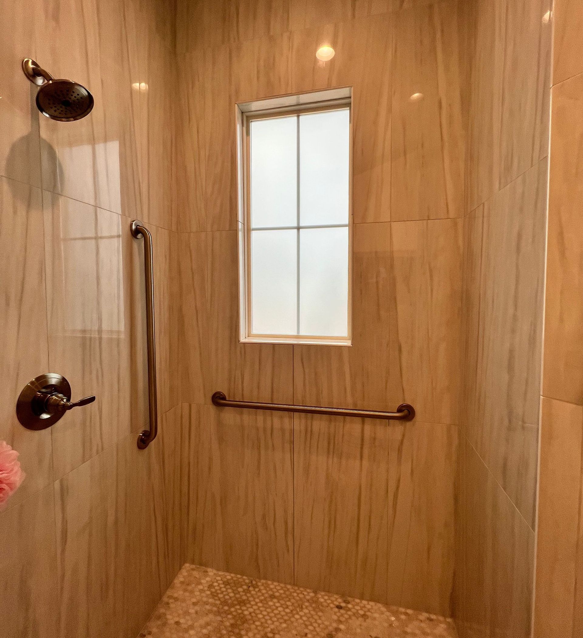 A bathroom with a walk in shower and a window