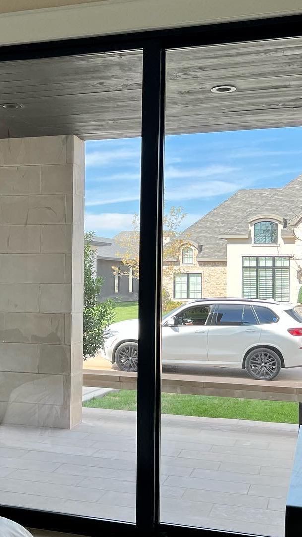 A white car is parked in front of a house.