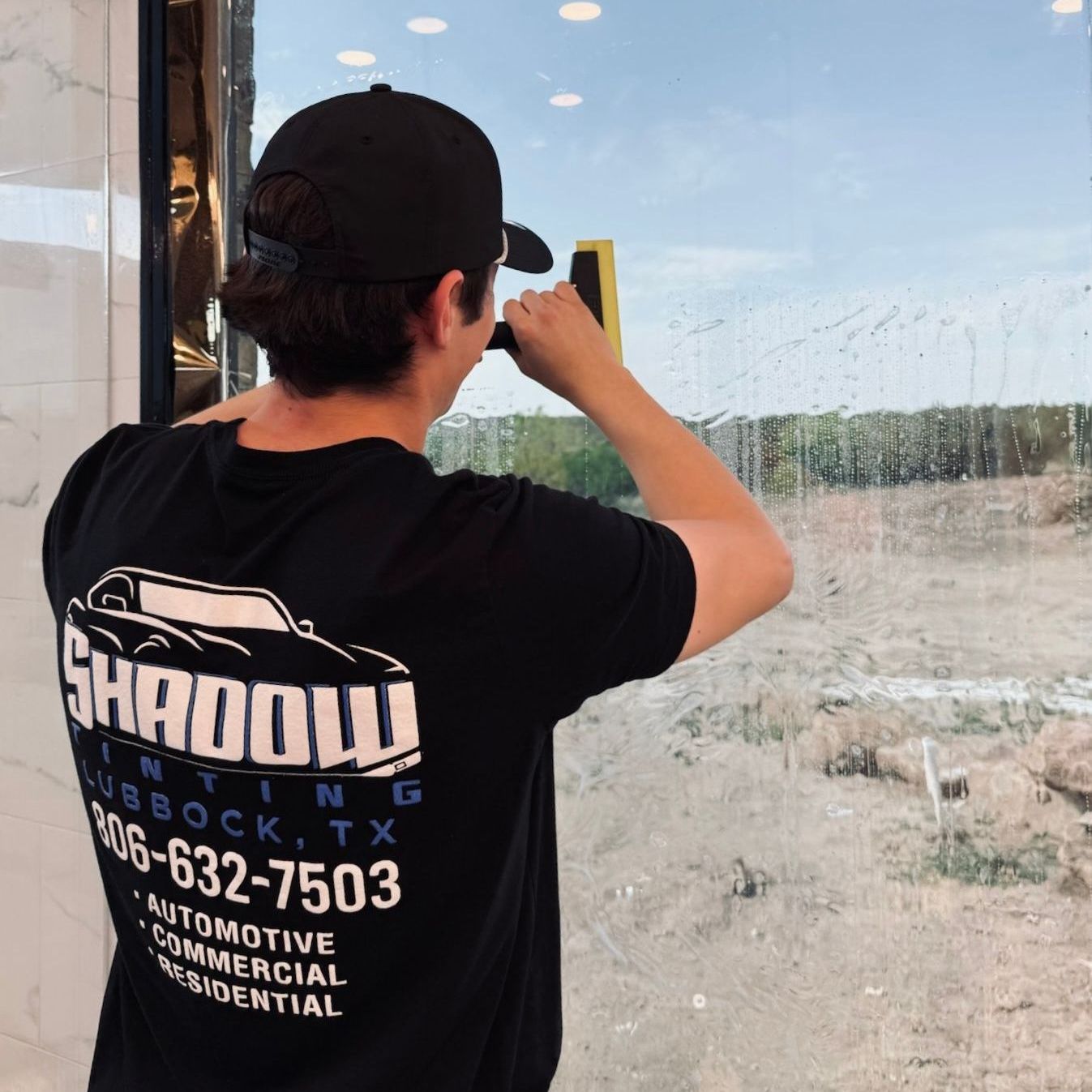 A man wearing a black shirt that says shadow on it
