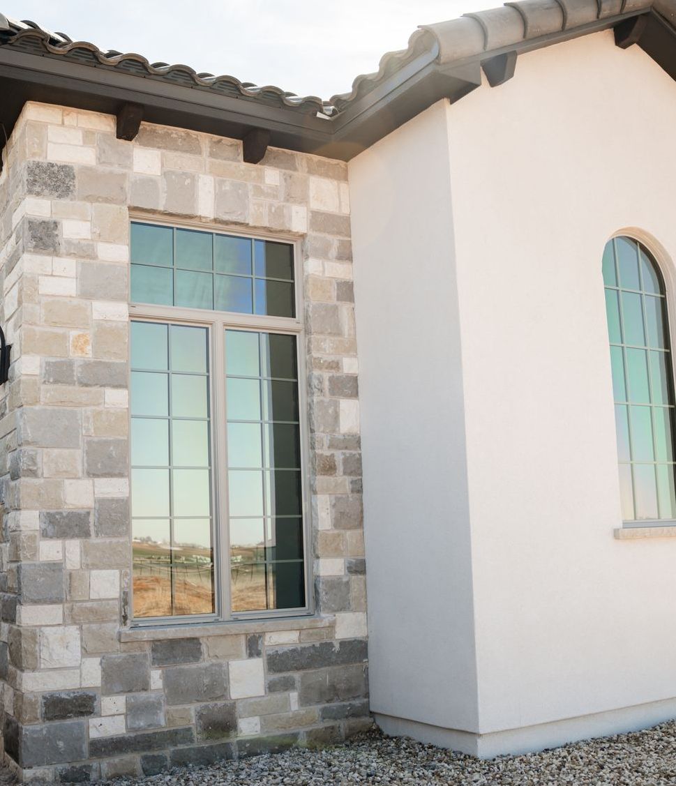 A white building with a brick wall and a window