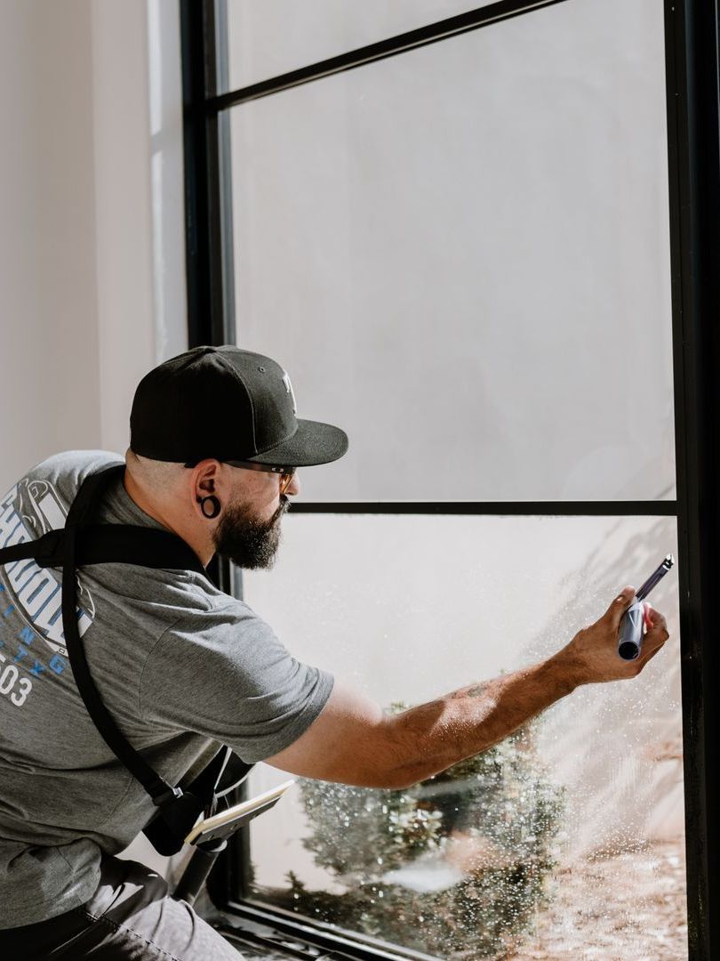 A man is cleaning a window with a brush.